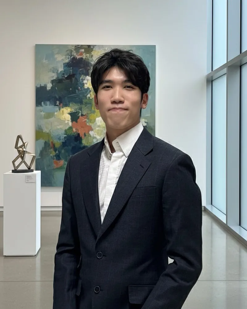 Chirath Soithong, standing in a gallery in a dark suit